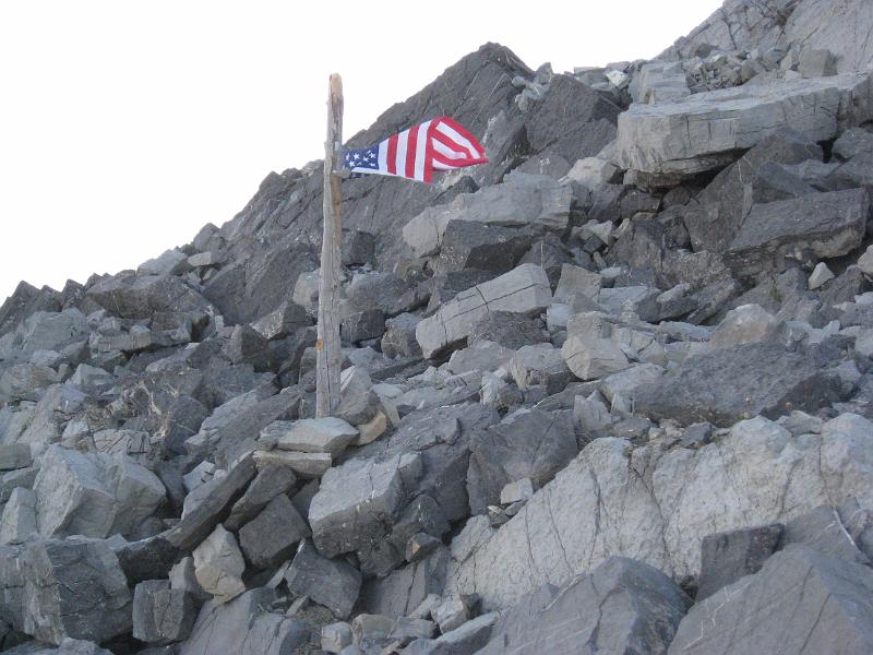 IMG_3696.jpg - A battered Amercan Flag stuck in the rock rubble on the side of the trai.  It was windy!